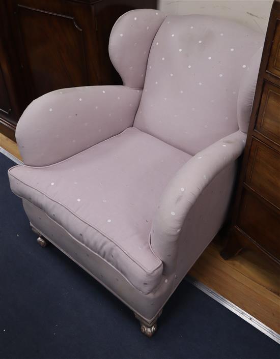 A pair of 1930s club style wing armchairs on silvered feet
